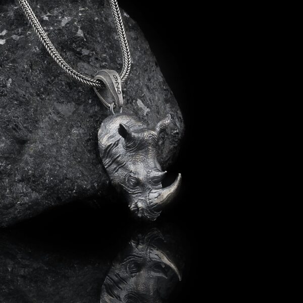 rhino necklace is a sterling silver jewelry piece that shaped as a head of rhino. it is made of silver.