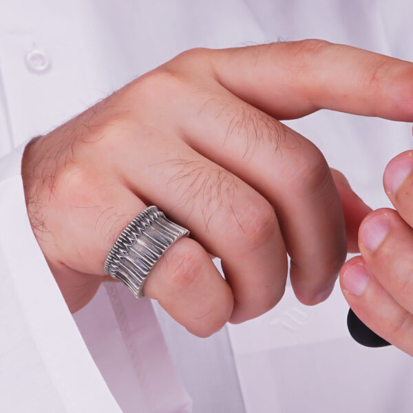 a man wearing oxidized gates of mordor ring